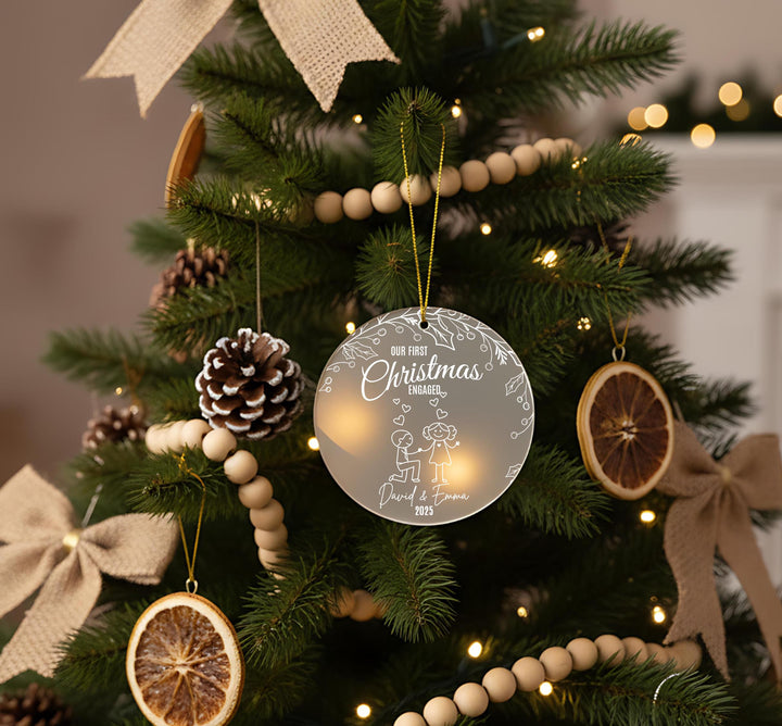 a Christmas tree decorated with ornaments, including a round ornament with a couple, pine cones, and dried fruit slices.